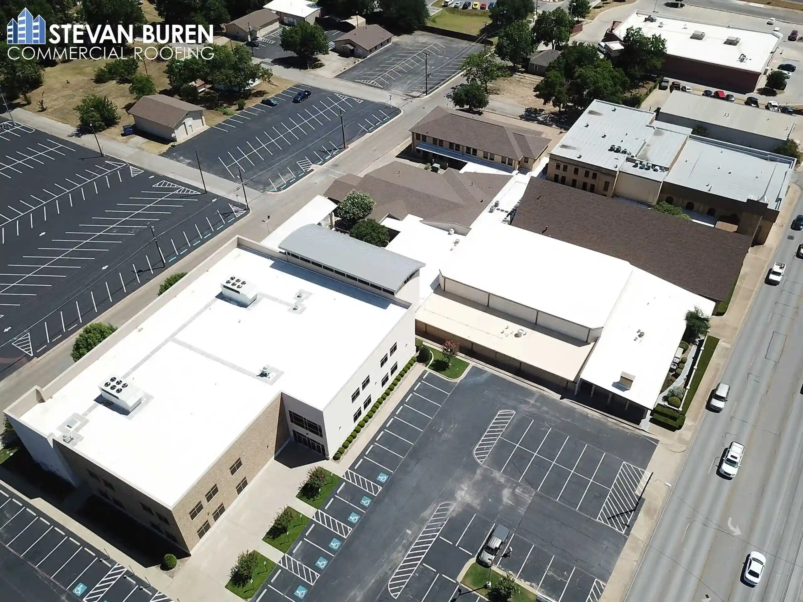 Aerial view of a church property with multiple commercial roofing systems