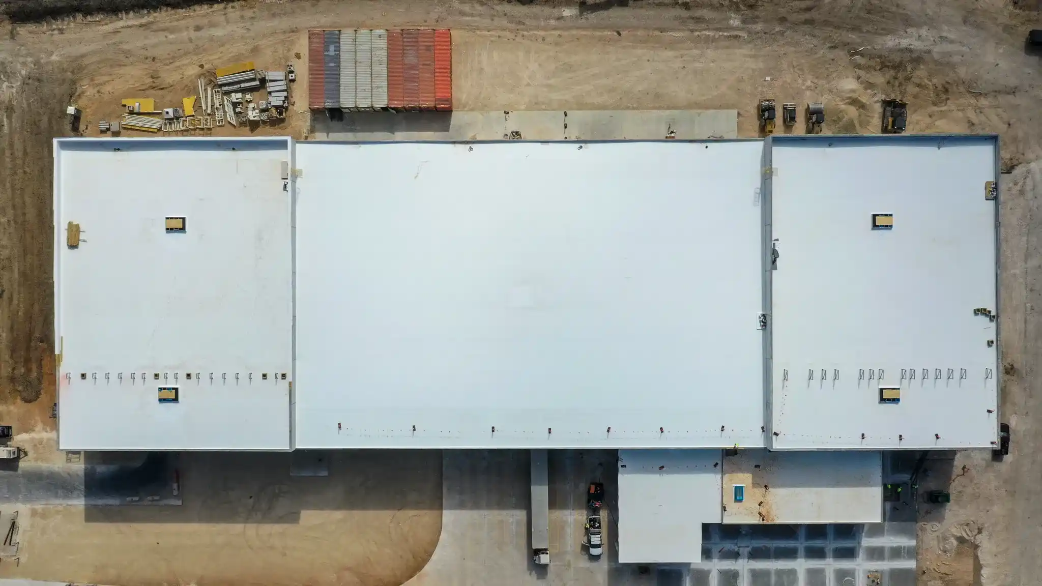 Top down aerial view of an industrial building with a white TPO roof system