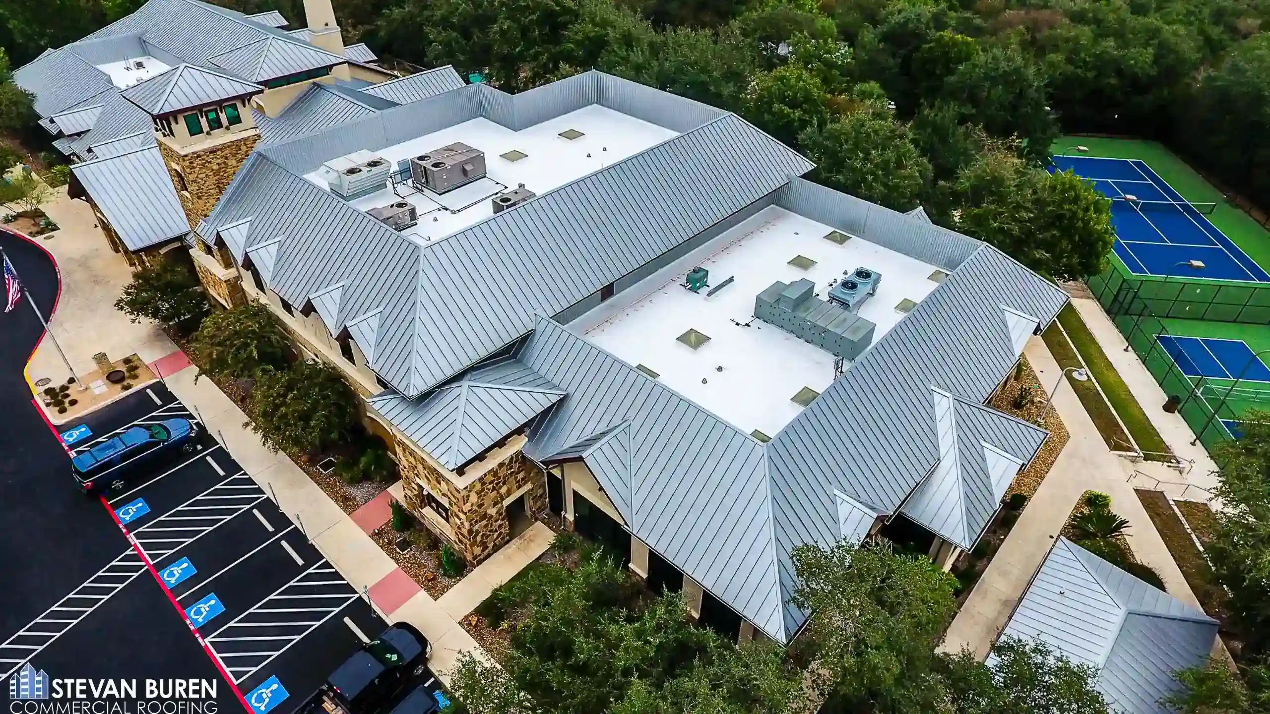 Aerial view of a resort building with standing seam metal roofing and TPO flat roof sections