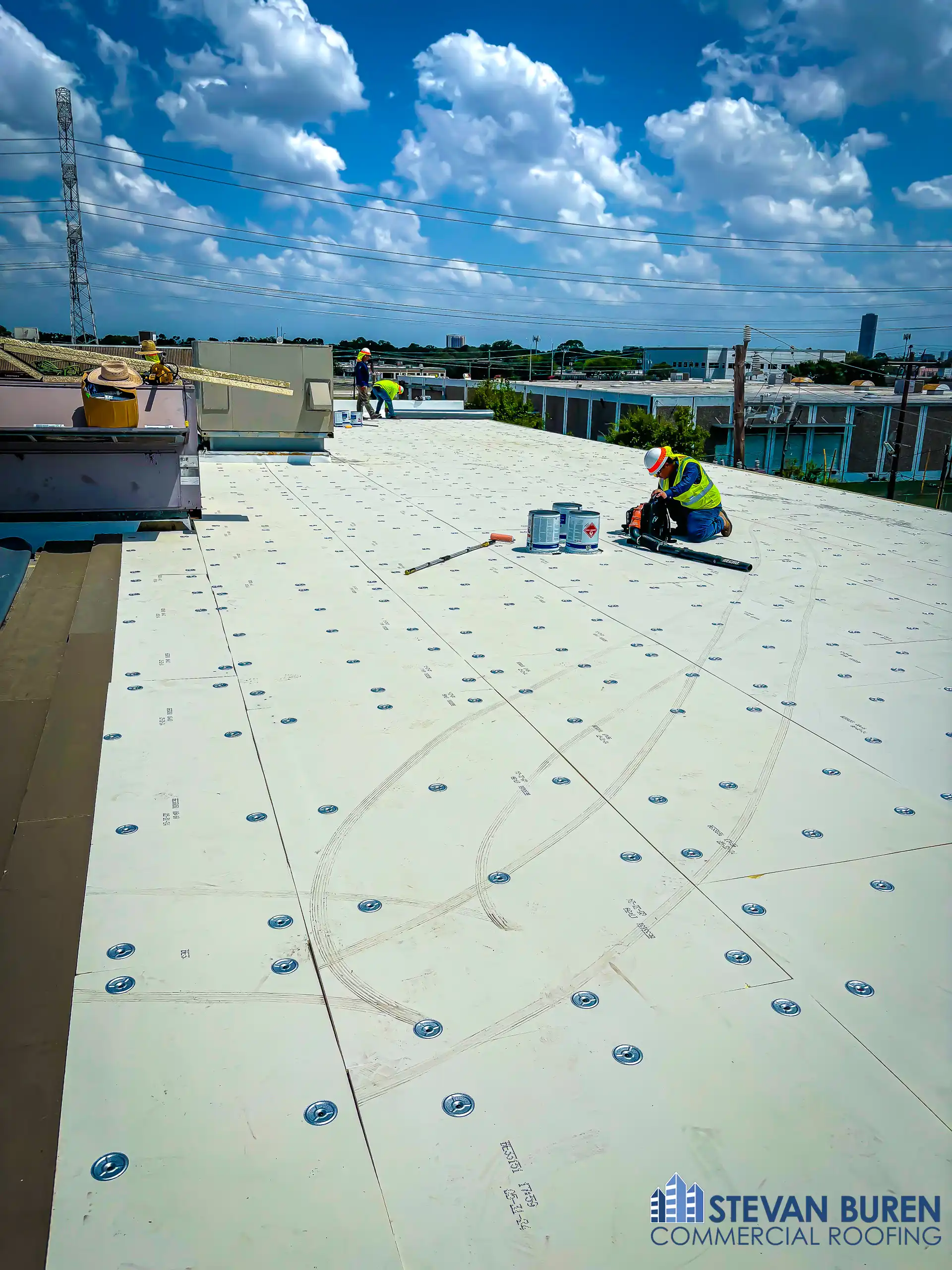 Early stage TPO roof installation on a commercial flat roof
